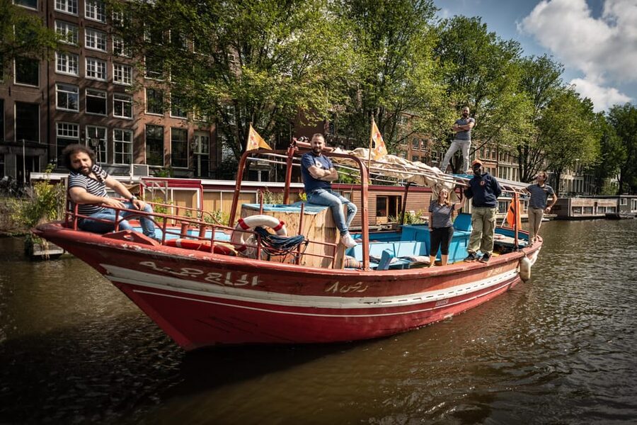 Amsterdam: Canal Cruise on a Wooden Refugee Boat - Rain, sun, and practical comfort